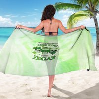 Green beach sarong with skull graphic and slogan print, held open by model