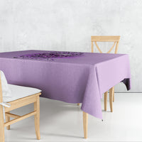 Purple printed tablecloth with text and floral graphic, draped on a table