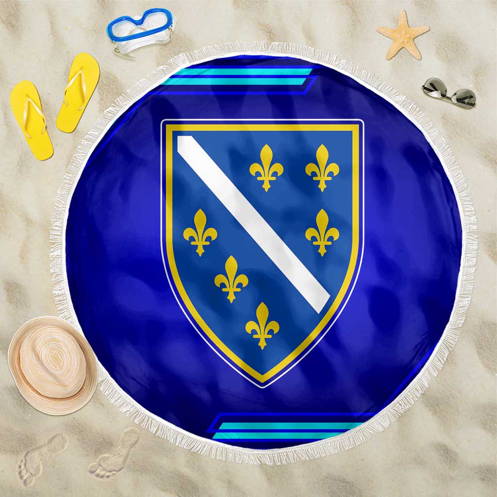 Round blue beach blanket with fringe edge, shield emblem and yellow fleurs-de-lis