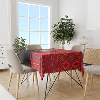 Rectangular tablecloth with red and black geometric pattern, draped over dining table