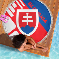 Round Slovakia flag beach blanket with crest and white fringe, laid on wood deck