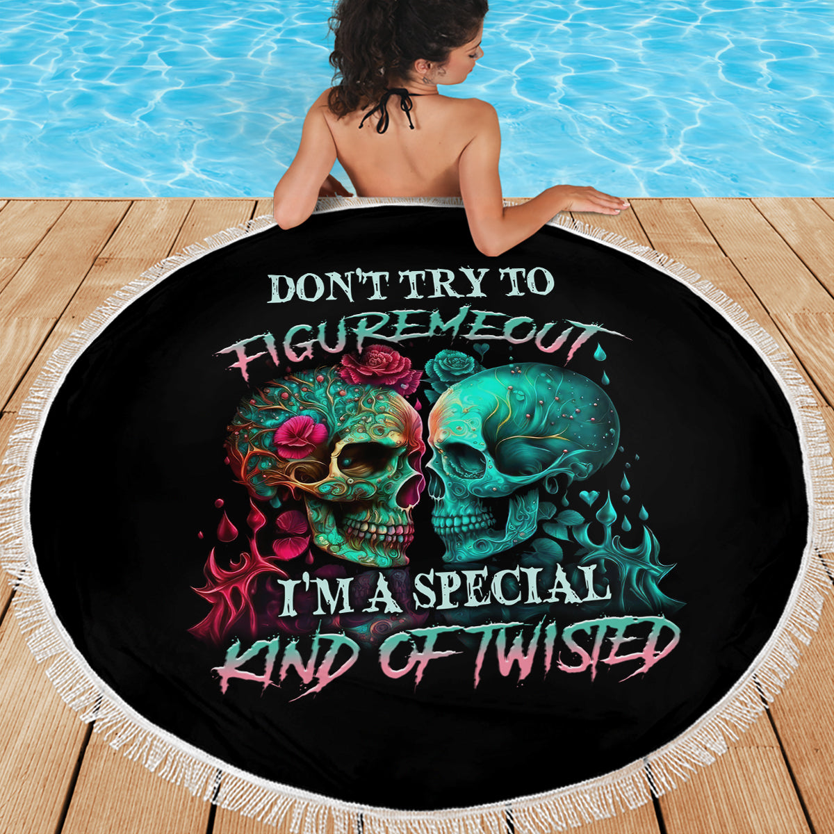 Round black beach blanket featuring multicolor skull artwork with white fringe border