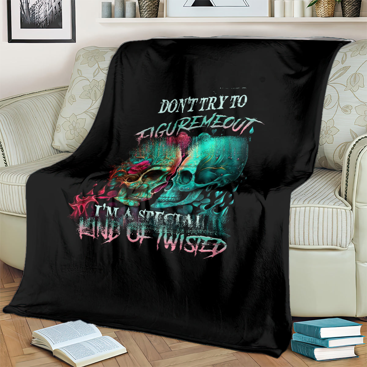 Black skull blanket draped over sofa, multicolor twin skull face graphic and text