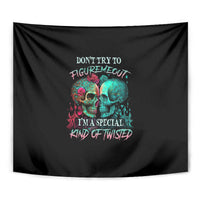 Black skull tapestry close-up with multicolor text and two skull faces.