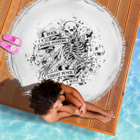 Round black-and-white printed beach blanket with fringe edges, graphic skull duel design