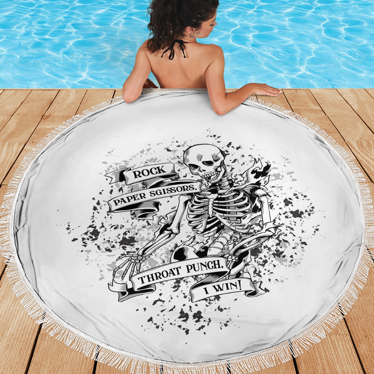 Round black-and-white skull graphic beach blanket with fringed edge, full view
