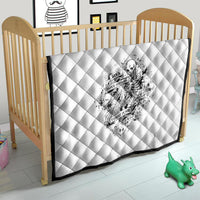 White diamond-quilted crib quilt with black-and-white skeleton graphic in the middle