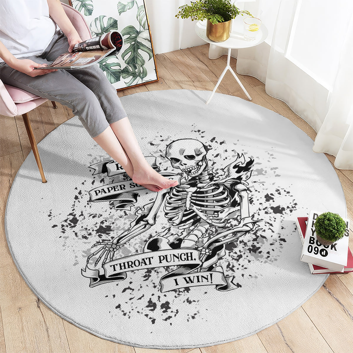 Round game rug with light gray base and black skeleton Rock Paper Scissors graphic