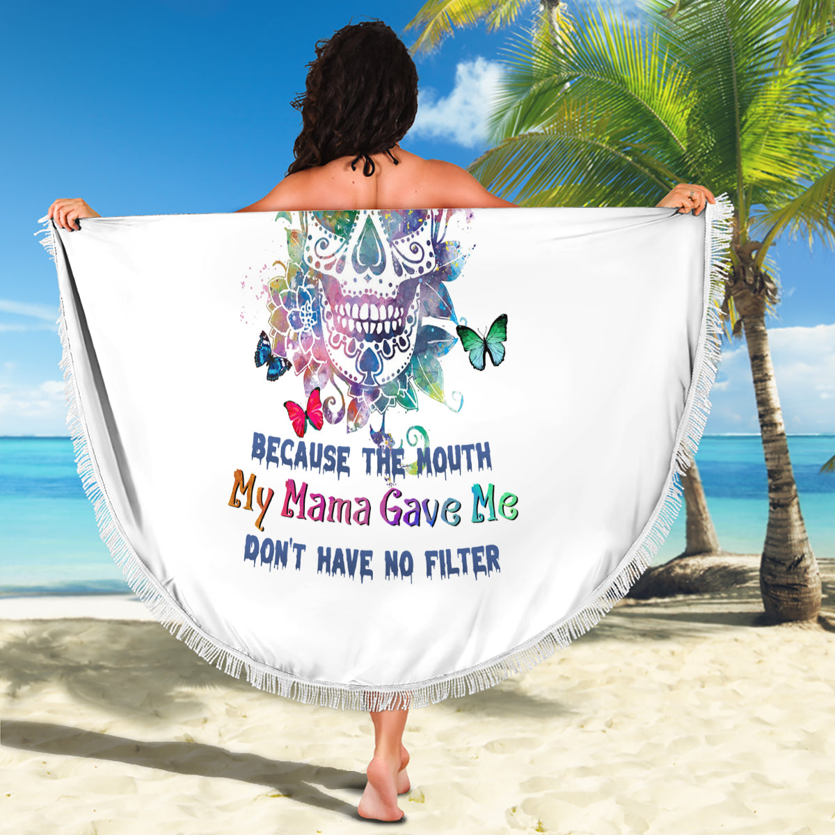 Multicolor sugar skull beach blanket with fringe trim, held open by model