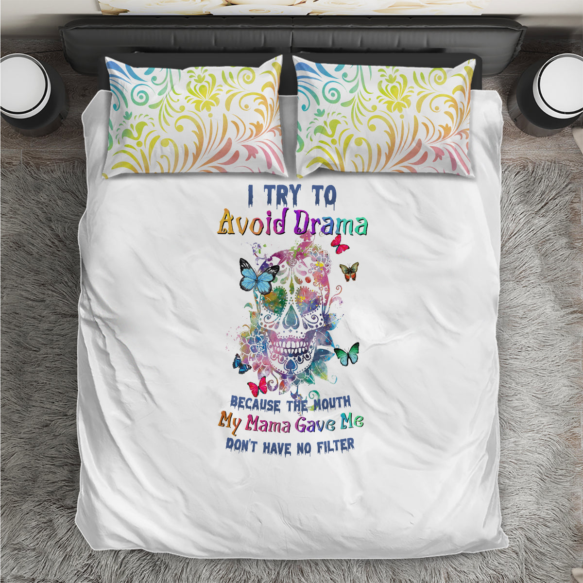 White bedding set with central sugar skull graphic and teal, yellow, pink swirl pillows