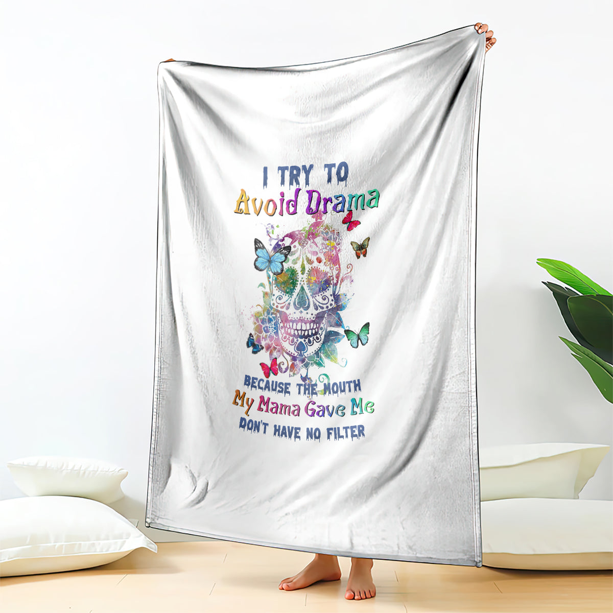 White throw blanket draped with colorful sugar skull, butterflies, and quote text