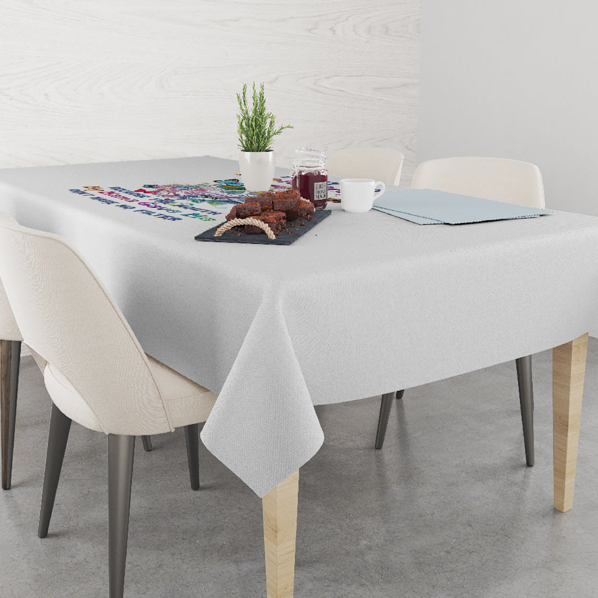 Grey tablecloth draped over dining table with colorful printed motif in center