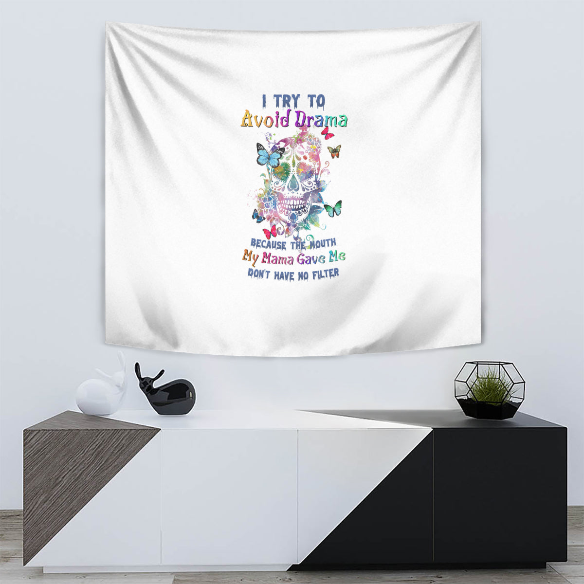 White tapestry wall hanging with colorful sugar skull, butterflies, and stacked multi-line text