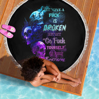 Round beach blanket with black background, skull flames graphic, and white fringe edge
