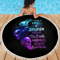 Round black beach blanket with skull and fire design, white fringed border