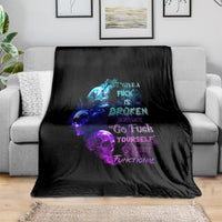 Black graphic throw blanket with blue and purple skull flame text, draped on couch