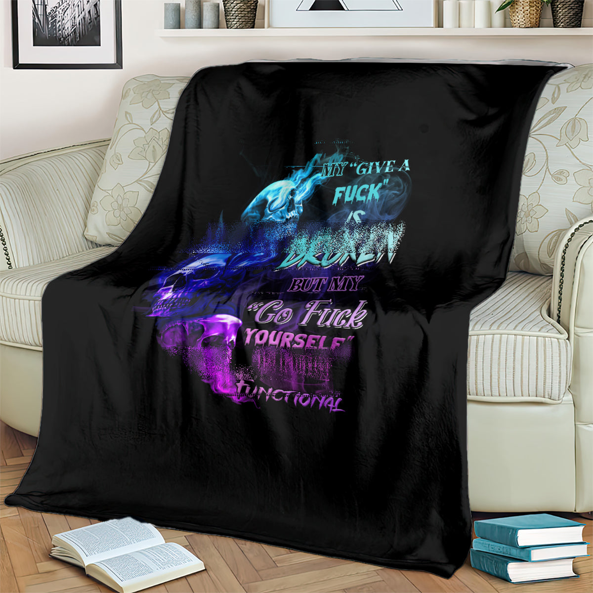 Black graphic throw blanket with blue and purple skull flame text, draped over sofa