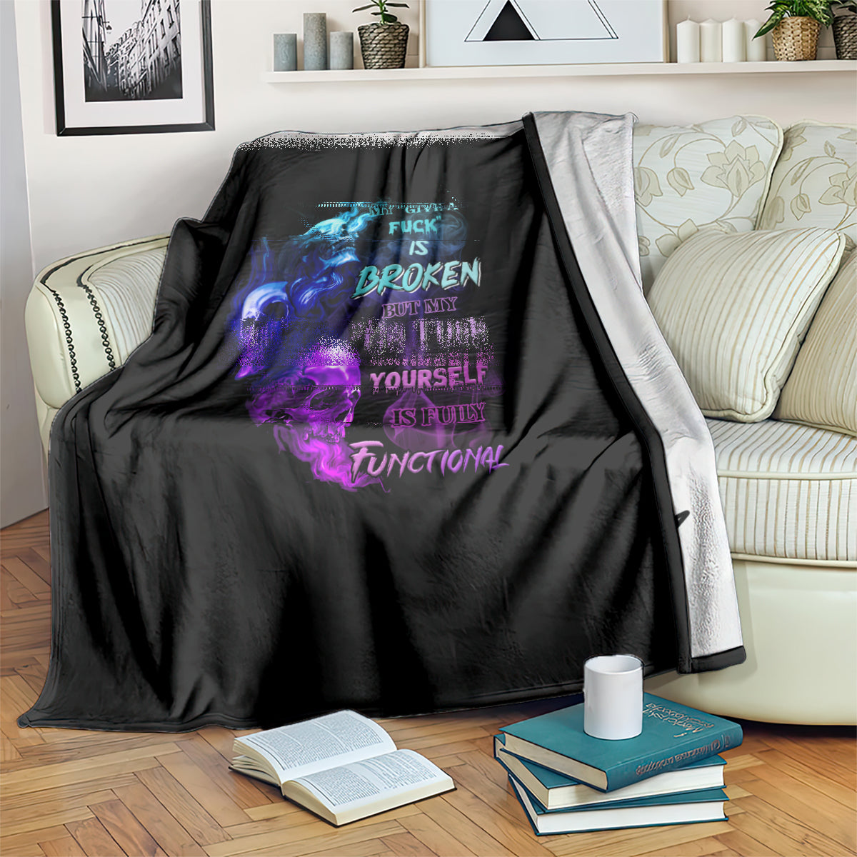Black graphic throw blanket with blue and purple skull flame graphic, folded over couch