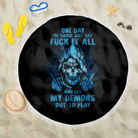 Round beach blanket laid flat: black fabric with blue skull print and white fringe.