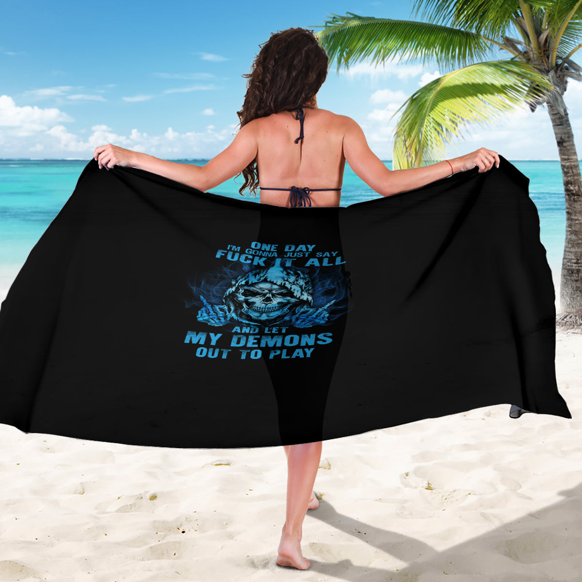 Black skull graphic sarong held open with blue print, wrap-style cover-up