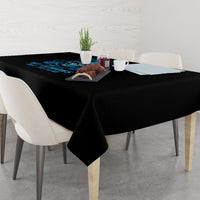 Black tablecloth on rectangular dining table with blue skull design at center