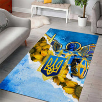 Blue decorative area rug with trident emblem and angel wings, with yellow sunflowers