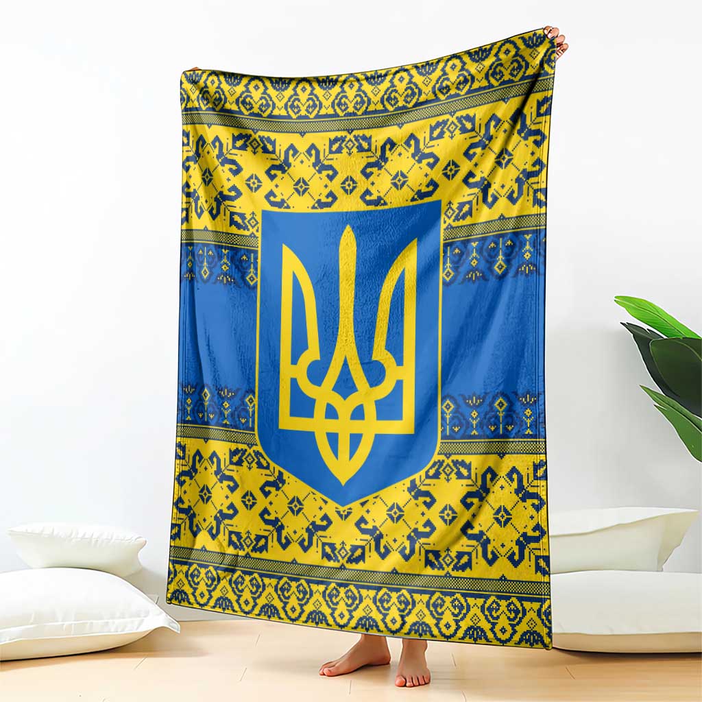 Blue and yellow throw blanket with large gold trident emblem, draped upright near pillows