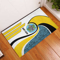 Rubber doormat with centered Saint Lucia crest, yellow and blue geometric band, stripes