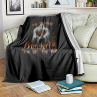 Black Halloween blanket on couch with ghost and jack-o-lantern, orange lettering design