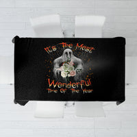 Black Halloween tablecloth with skull bouquet graphic and orange lettering across center