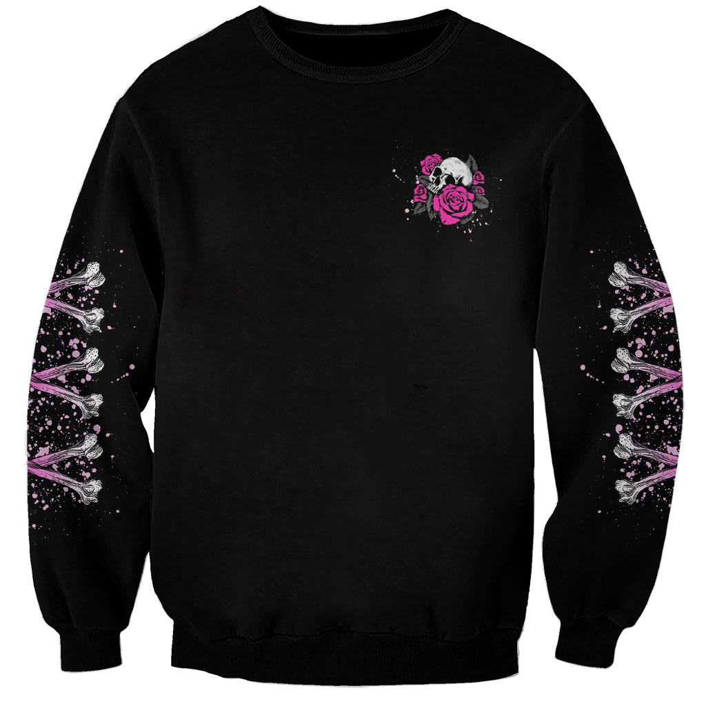 Black crewneck sweatshirt with small pink skull and rose graphic on chest.