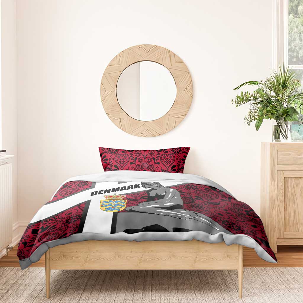 Red Denmark-themed duvet with mermaid graphic and two pillowcases on a wooden bed
