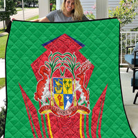 Green quilted blanket with red crest and shield emblem in center, quilt pattern border.