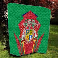Green quilted throw blanket with central red-and-green coat of arms emblem and textured quilting.