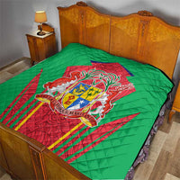 Green quilted bed throw with central red crest shield emblem and decorative flag-like rays.