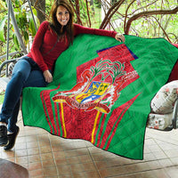 Green quilted blanket laid across sofa, showing central red crest shield emblem on quilted surface.