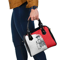 Shoulder handbag angled view with red panel, white print, black strap and handles