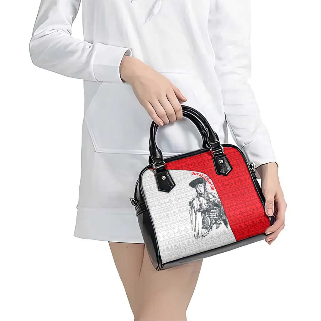 Shoulder handbag with red and white folk panel, black handles, on white outfit