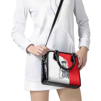 Crossbody shoulder bag with black strap, red-and-white panel graphic, black buckle details