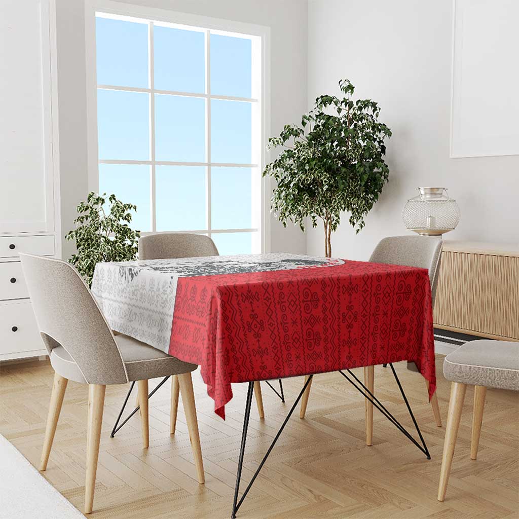Red folk-pattern tablecloth with matching dark motifs draped over a dining table