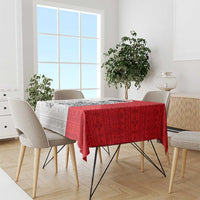 Red folk-pattern tablecloth with matching dark motifs draped over a dining table