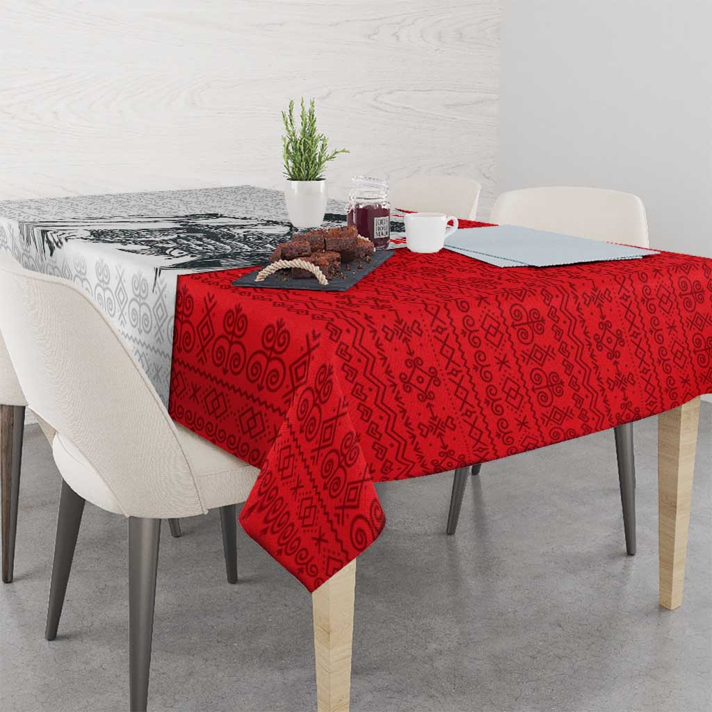 Rectangular tablecloth in red with folk motif pattern, draped over a tabletop