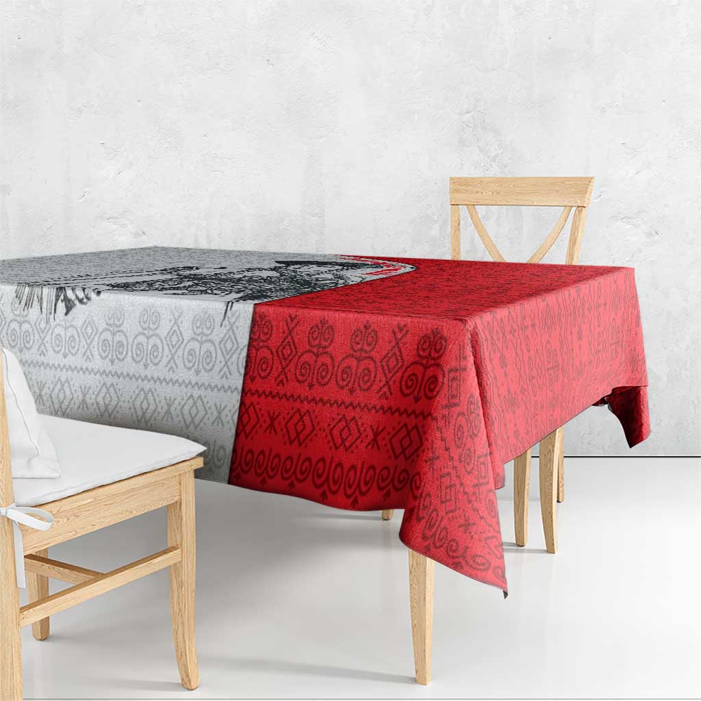 Red folk-pattern tablecloth with geometric motifs, overhanging the table edge