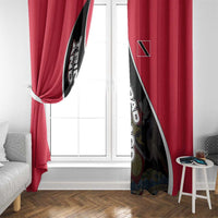 Red window curtain with black-and-white diagonal crest design beside white door