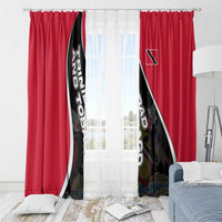 Red window curtains with black-and-white diagonal crest print over sheer light fabric