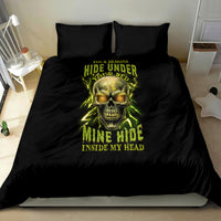 Black bedding set on bed with neon yellow skull graphic and two pillowcases.