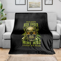 Black throw blanket draped on sofa, neon skull graphic with yellow-green text