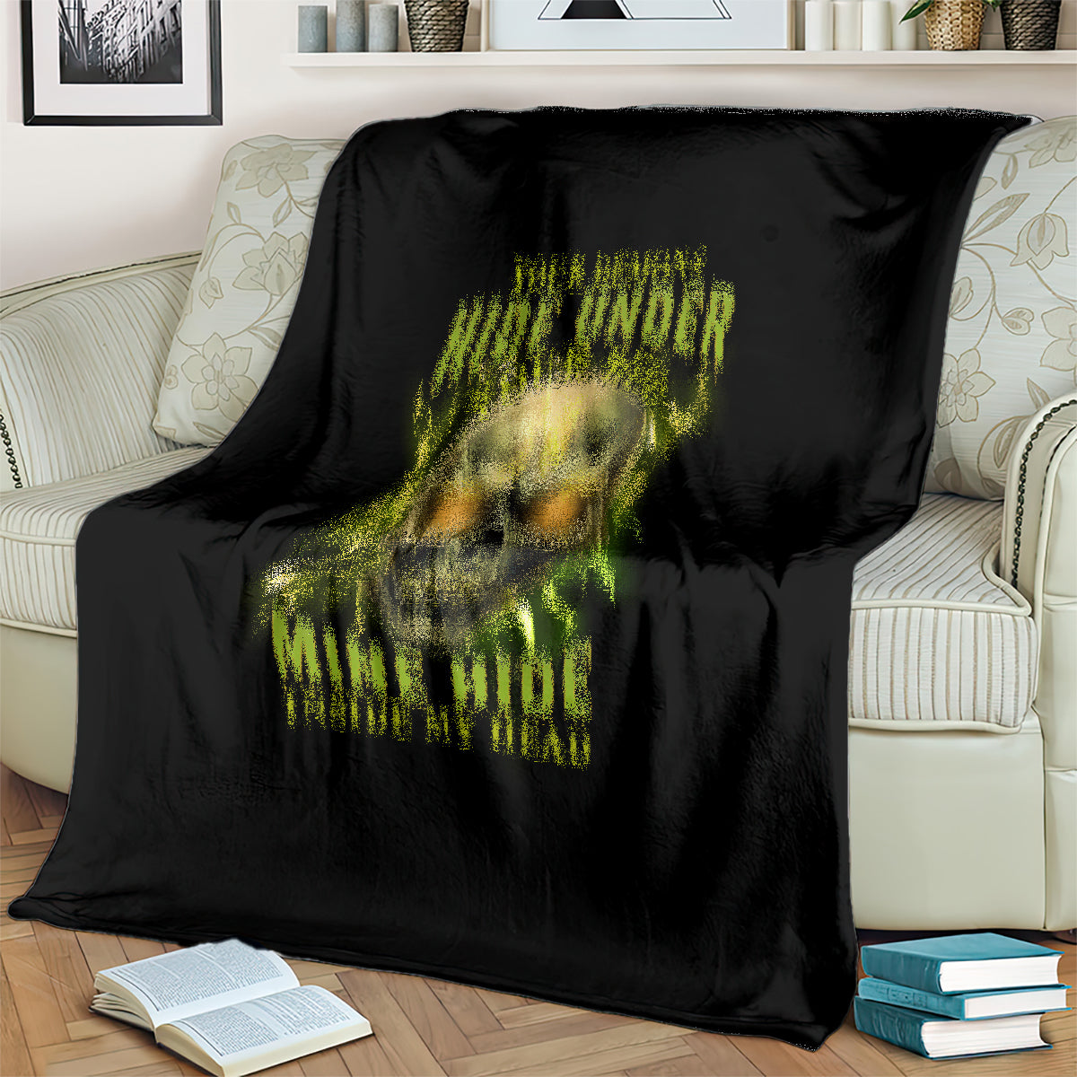 Black throw blanket on sofa, neon skull graphic and yellow-green lettering