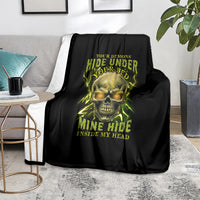 Black throw blanket on sofa with neon skull graphic, yellow-green horror lettering