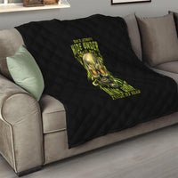 Black quilt on a sofa with neon skull and glow text, quilted diamond pattern